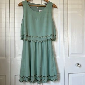 Lightweight sleeveless seafoam dress with gold beaded scalloped hem and waist.